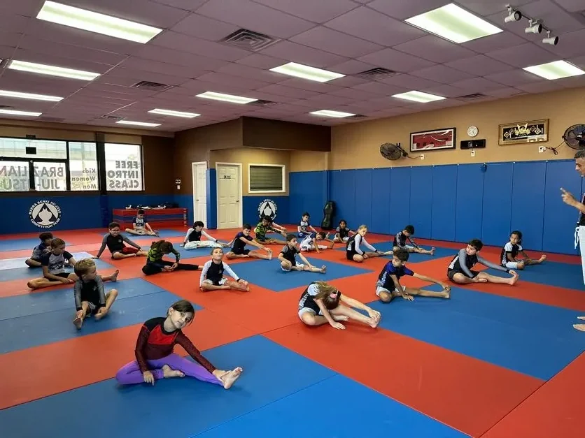 Kids warming up on the mat during a Jiu-Jitsu class